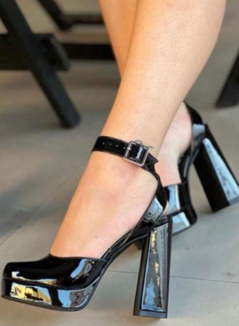 Patent leather platform sandals with a 10 cm block heel, combining height and comfort for a chic, modern look.